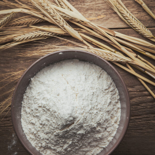 Flour and wheat flat lay on a wooden background